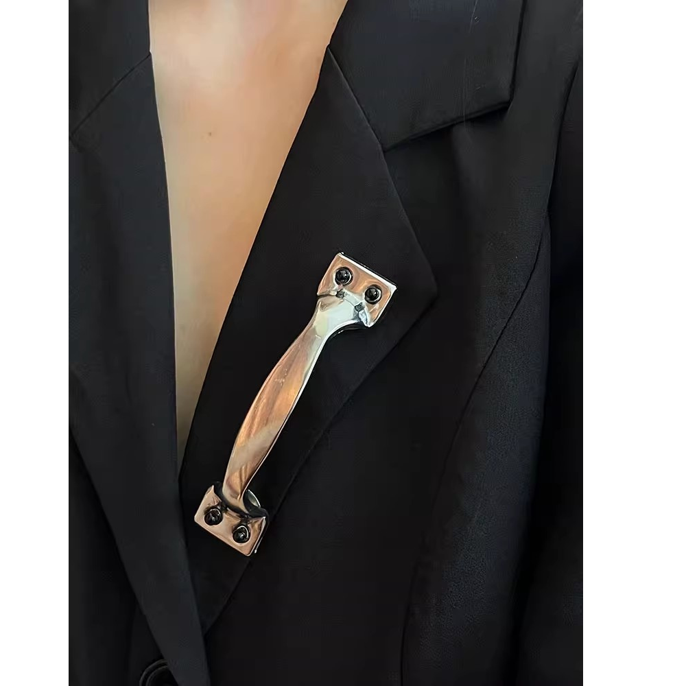 Black blazer with a decorative brooch on a white background