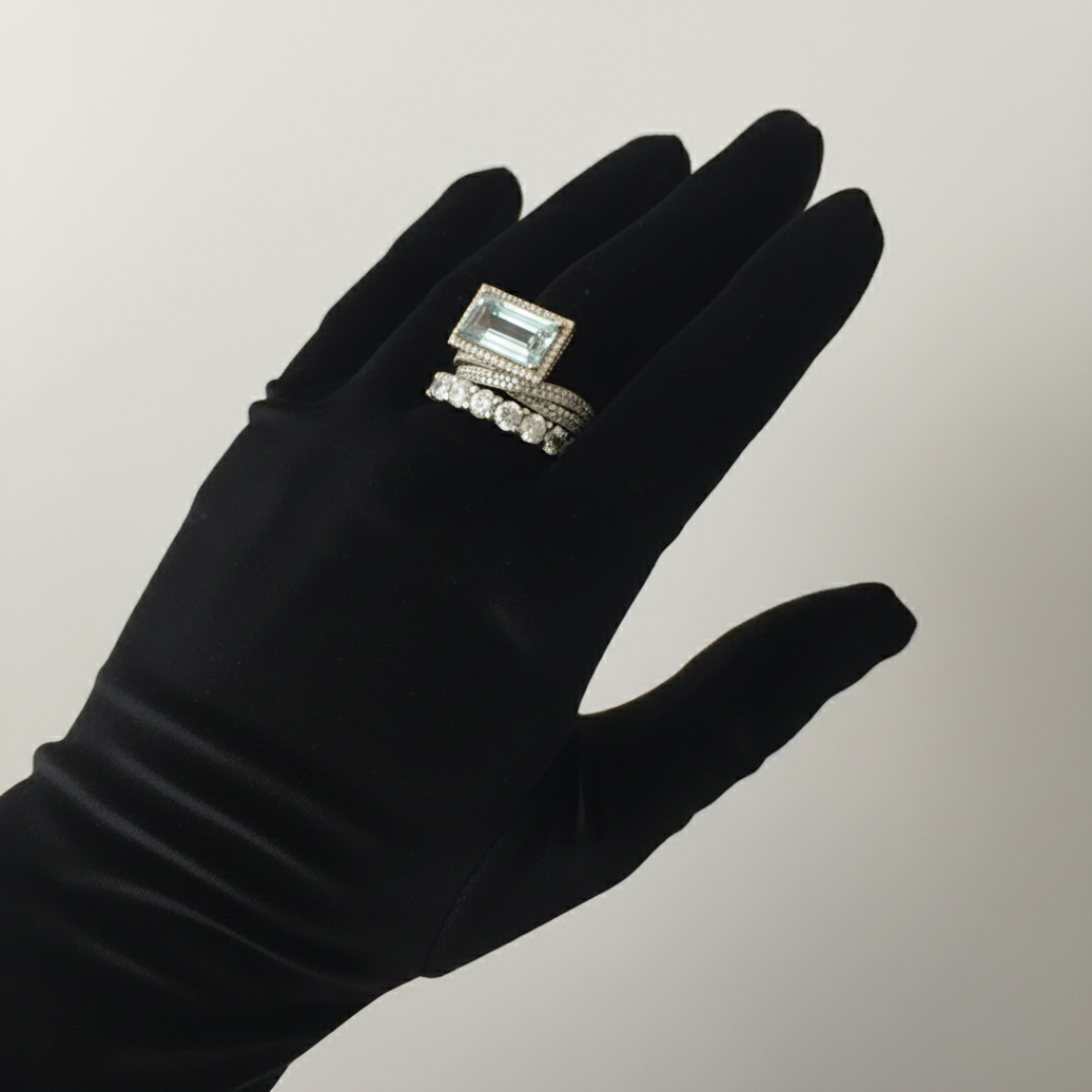 Black glove with a ring on a neutral background