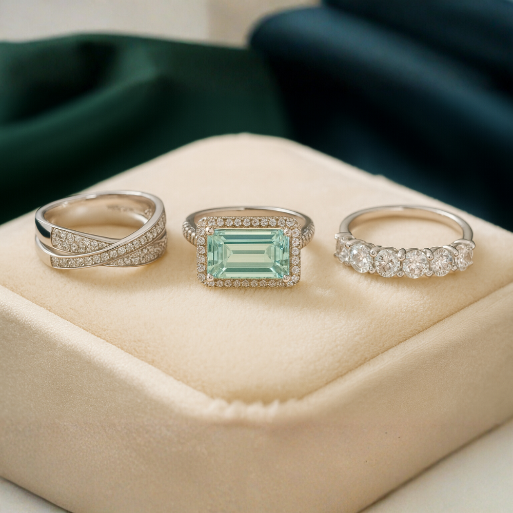 Three rings on a beige cushion with a green satin background